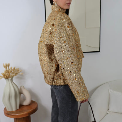 Veste dorée ornée de sequins pour une touche de glamour

Ajoutez une note de sophistication à votre tenue avec notre veste dorée ornée de sequins, parfaite pour les événements et occasions spéciales. Avec ses deux grandes poches sur le devant, elle allie fonctionnalité et élégance. La fermeture par boutons dorés apporte une finition chic, tandis que sa polyvalence vous permet de l’associer à des styles décontractés comme à des tenues plus habillées. Cette pièce incontournable rehaussera chaque look, apporta