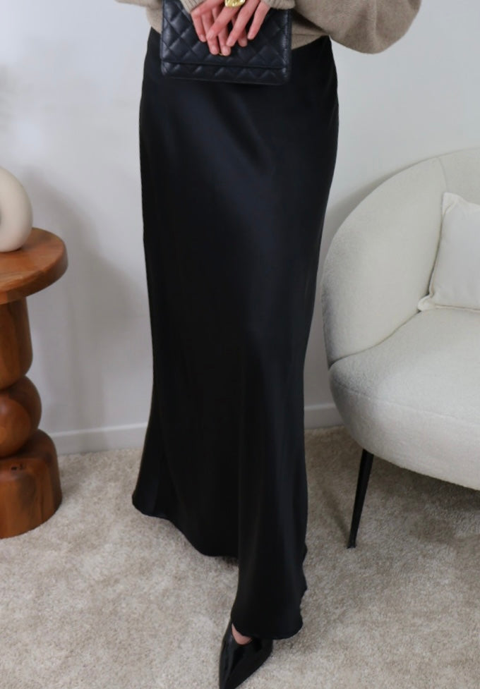 Jupe extra longue en satin noir avec fermeture éclair latérale, conçue pour sublimer la silhouette et offrir un ajustement parfait. Idéale pour les grandes tailles, cette jupe fluide est disponible en plusieurs couleurs. Modèle porté en taille M, longueur 112 cm