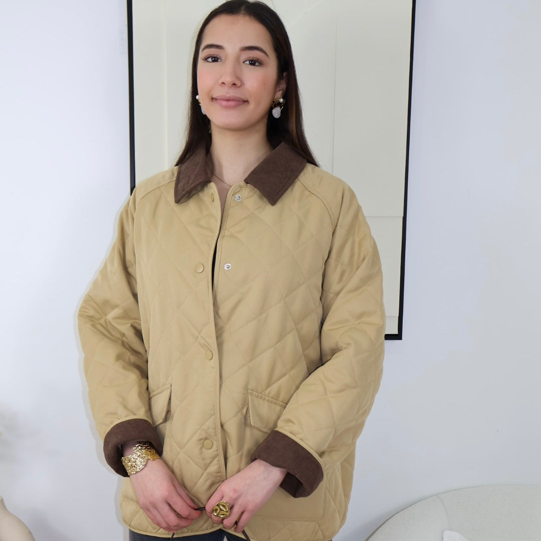 Veste matelassée camel avec finition en velours

Élevez votre style avec notre veste matelassée camel, alliant confort et élégance. Dotée de deux grandes poches à l’avant, elle offre une touche pratique tout en restant tendance. Sa fermeture par boutons à pression assure une utilisation aisée. L’intérieur des manches en velours marron et le col à revers en velours ajoutent une finition raffinée. Parfaite pour les journées fraîches, cette veste devient un indispensable de votre garde-robe.
